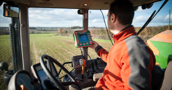 Tracteur, vue de la cabine, dans un champ avec du matériel d'exploitation