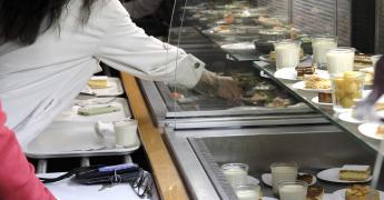 Rampe de self service avec des plateaux remplis dans un restaurant collectif