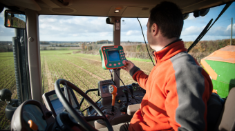 Tracteur, vue de la cabine, dans un champ avec du matériel d'exploitation
