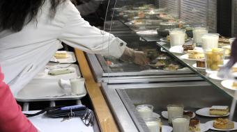 Rampe de self service avec des plateaux remplis dans un restaurant collectif